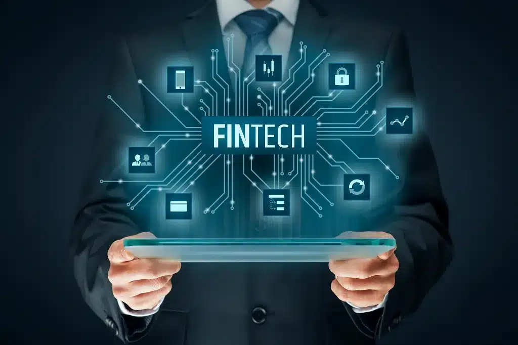 Man using laptop with fintech icons, data charts, and digital financial interface